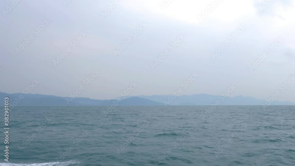 View of sea and mountains from side of moving boat, slow motion View of sea and mountains from side of moving boat, slow motion