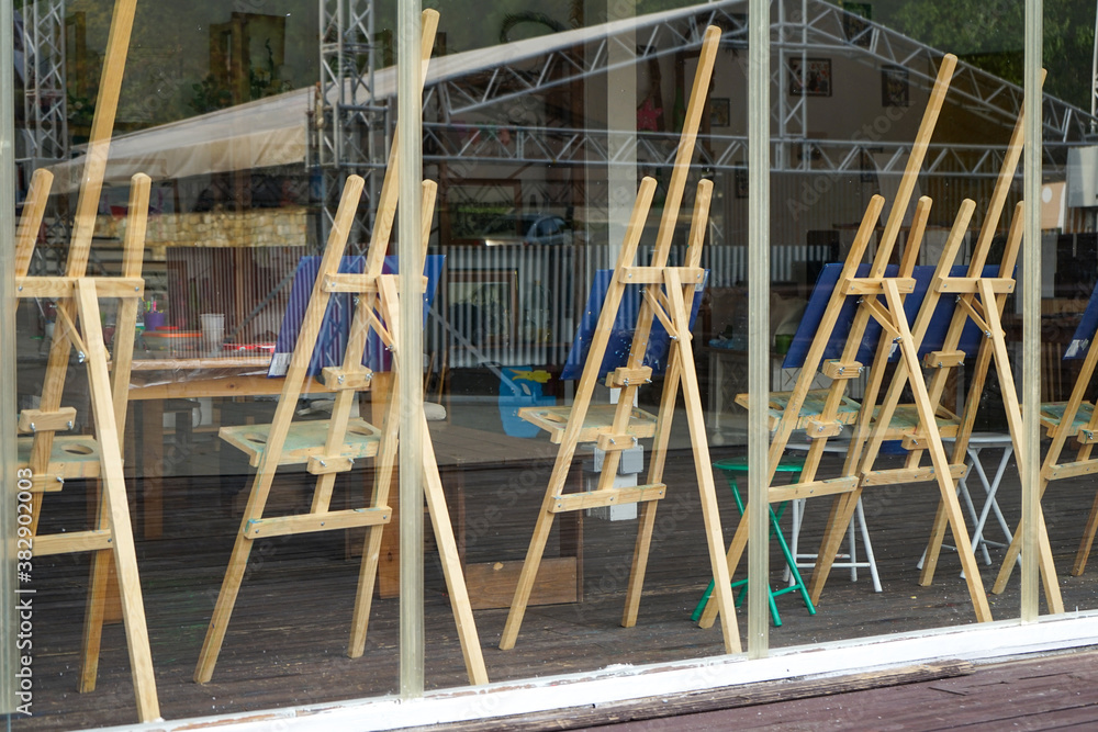 a large number of easels empty and with unfinished works in a closed art Studio without people a large number of easels empty and with unfinished works in a closed art Studio without people