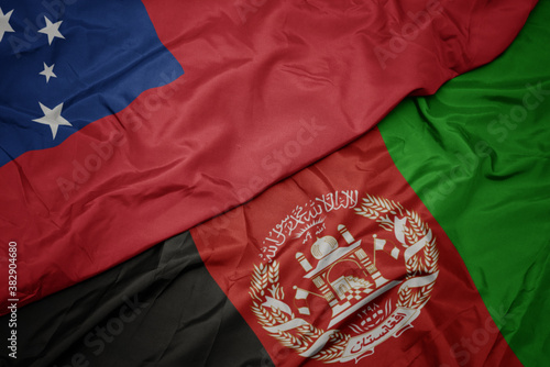 waving colorful flag of afghanistan and national flag of Samoa . macro