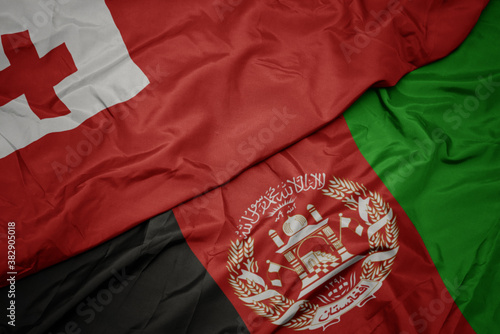 waving colorful flag of afghanistan and national flag of Tonga . macro