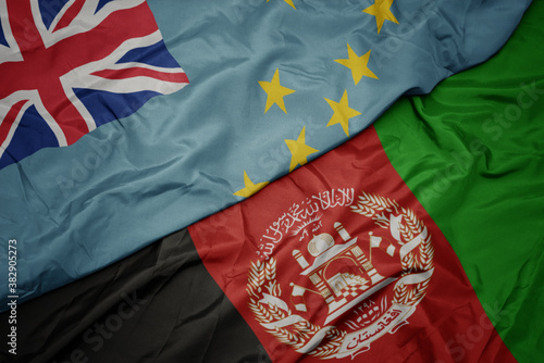 waving colorful flag of afghanistan and national flag of Tuvalu . macro