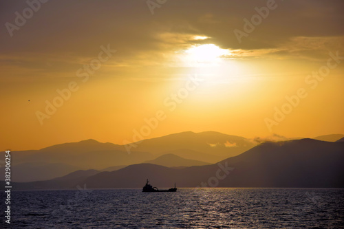 cargo ship travels at sunset
