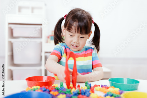 young girl play math and color sorting fine motor skill game for  homeschooling