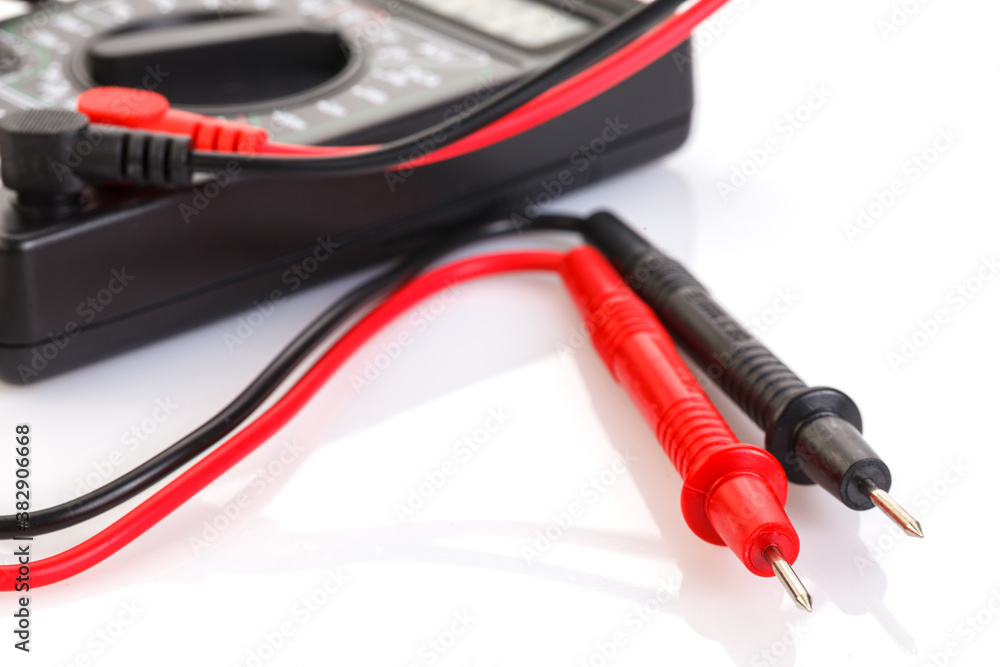 Digital electrical tester multimeter in black case isolated on white background. Digital multimeters have a numeric display, can measure voltage, current and resistance. Close-up. Digital electrical tester multimeter in black case isolated on white background. Digital multimeters have a numeric display, can measure voltage, current and resistance. Close-up.
