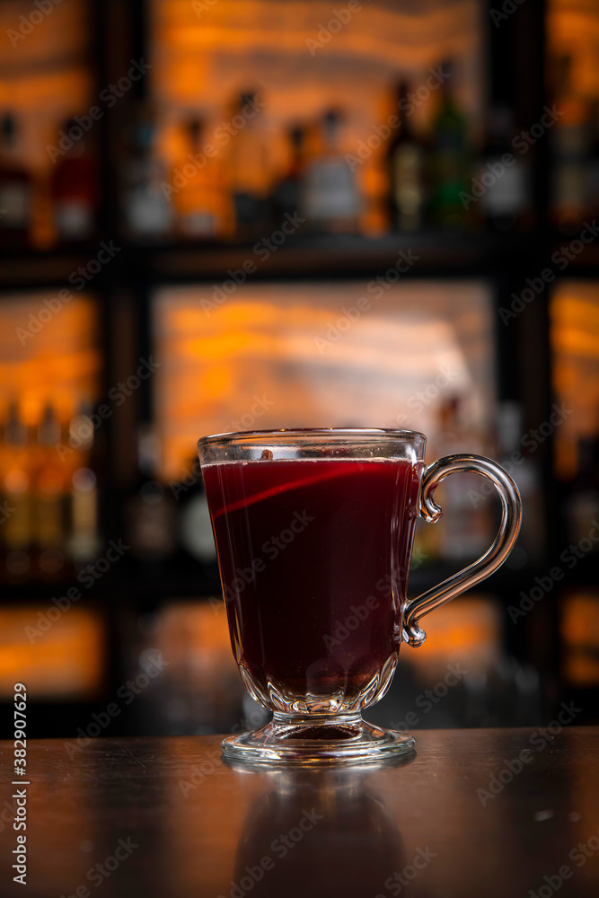 A young smiling bartender in a black apron prepares mulled wine
A young smiling bartender in a black apron prepares mulled wine