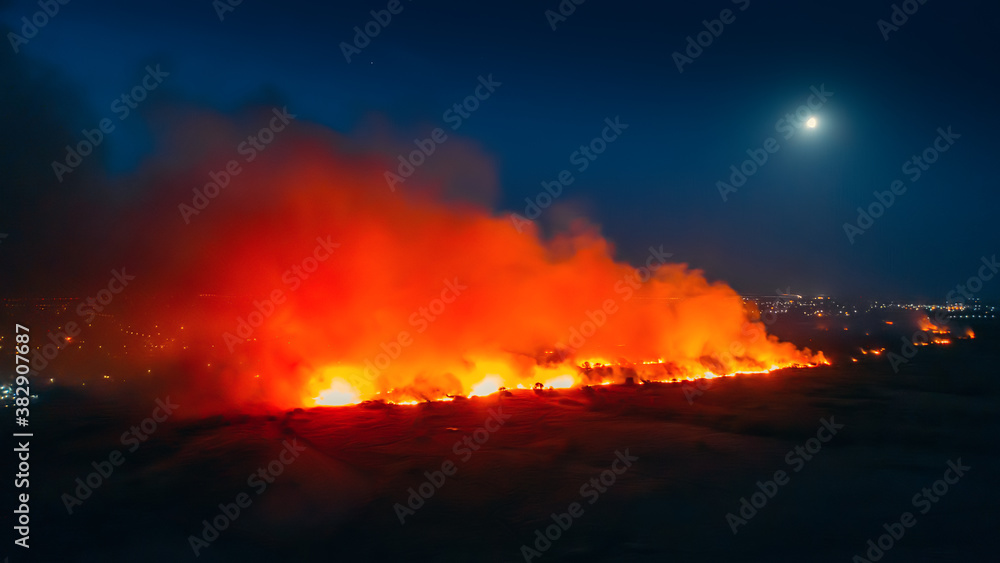 Flames of massive Forest Fire, aerial view at night. Nature wildfire in dry season.