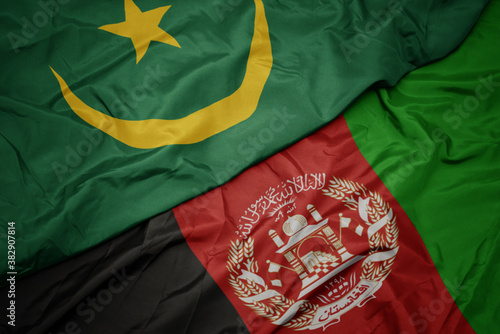 waving colorful flag of afghanistan and national flag of mauritania. macro