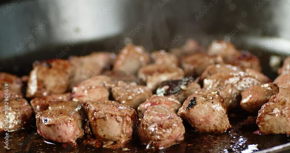 Pieces of liver are fried in a frying pan with hot steam. Pieces of liver are fried in a frying pan with hot steam.