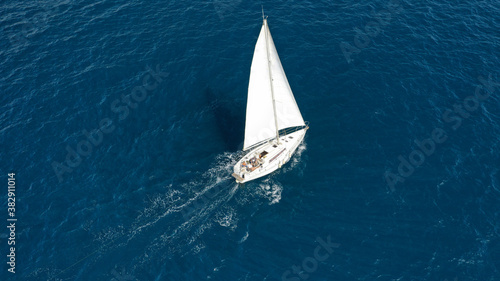Aerial drone photo of small sailboat cruising deep blue Ionian sea © aerial-drone