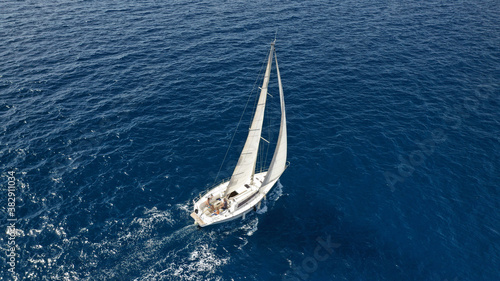 Aerial drone photo of small sailboat cruising deep blue Ionian sea