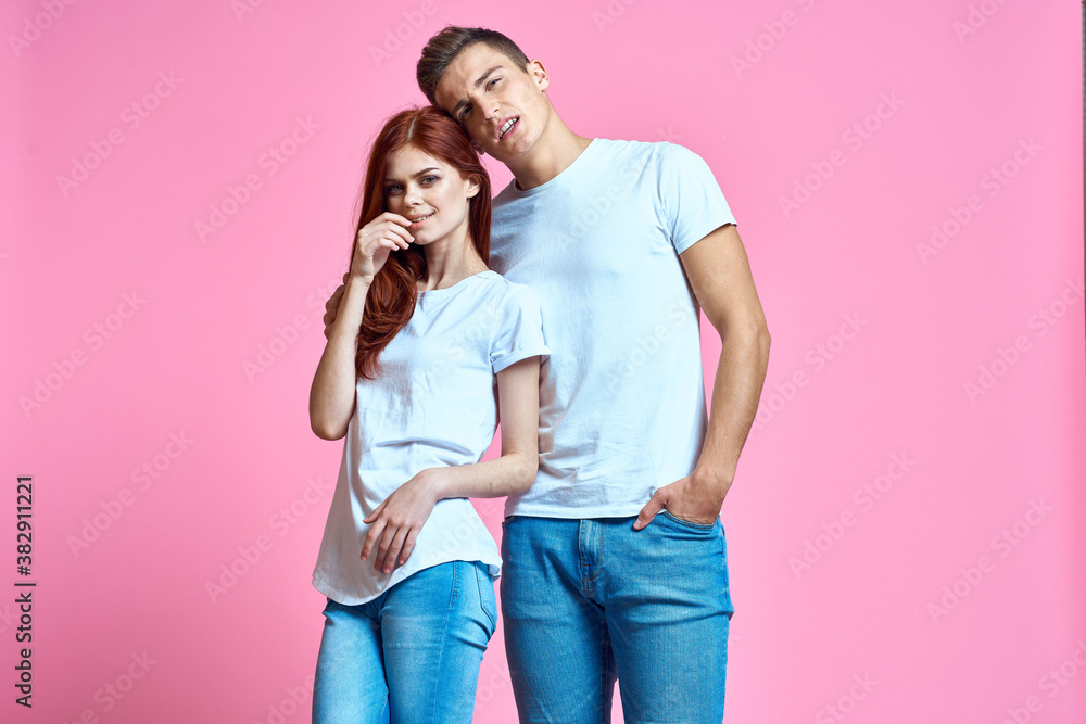 Naklejka premium lovers man and woman in jeans and t-shirt on pink background cropped view family romance teenagers
