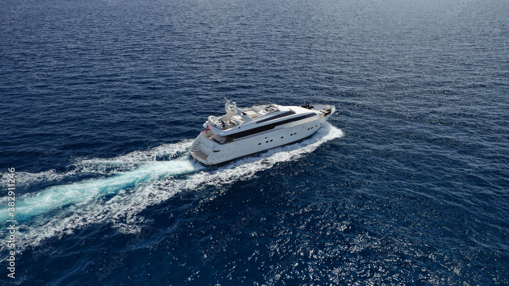 Naklejka premium Aerial drone photo of small luxury yacht cruising the Aegean deep blue open ocean sea