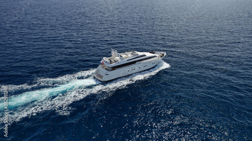 Aerial drone photo of small luxury yacht cruising the Aegean deep blue open ocean sea