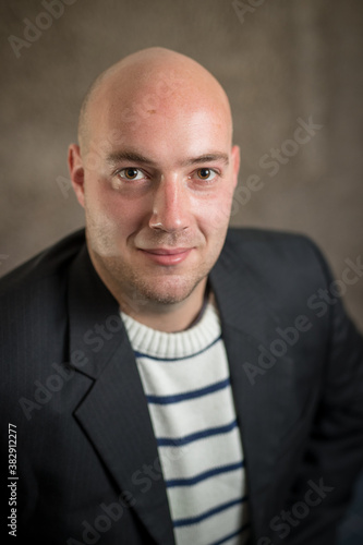 Portrait of modern business hipster crypto man in a striped sweater and a black dress or jacket on a grey background. Corporate portrait of young business man photo