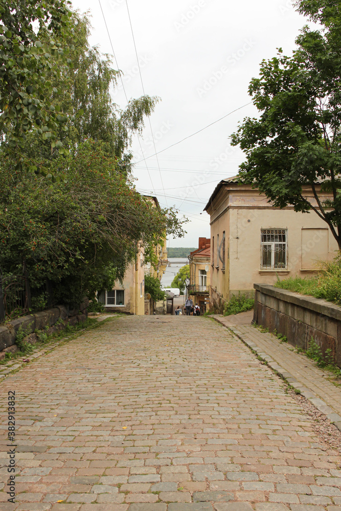 street in the city. The road from the ancient paving stone leading down and a small bright house