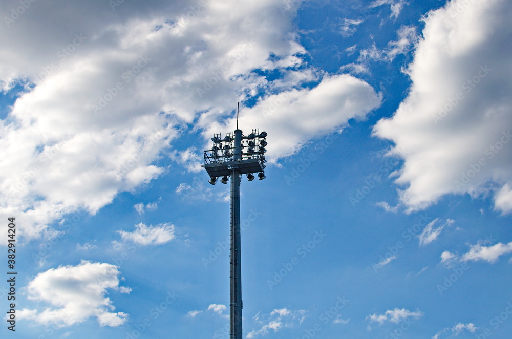 Stadium spot-light tower on blue cloudy sky background Stadium spot-light tower on blue cloudy sky background