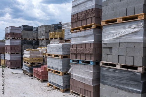 Industrial production of building cement pressed materials. High quality hollow concrete block or cement brick and paving stones. Finished products on pallets packed in film are waiting to be shipped.