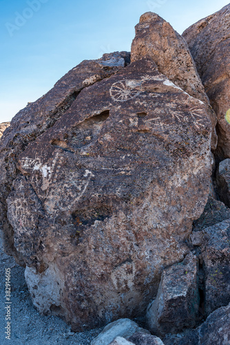 ancient petroglyphs of indigenous people incised into rock face boulders in desert landscape Owens Valley California photo