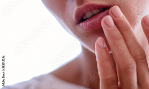 herpes on the lips, part of a woman's face with finger on lips with herpes, beauty concept
