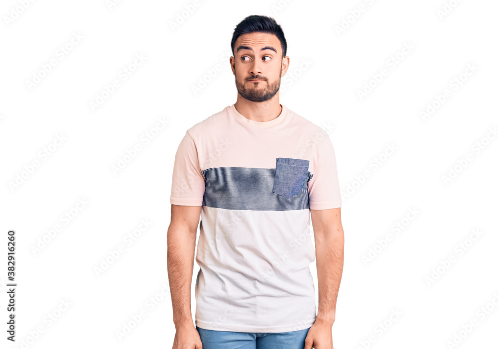 Fototapeta premium Young handsome man wearing casual clothes smiling looking to the side and staring away thinking.