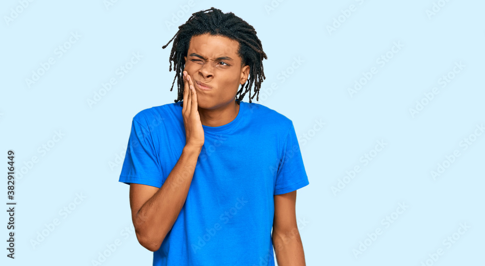 Young african american man wearing casual clothes touching mouth with hand with painful expression because of toothache or dental illness on teeth. dentist Young african american man wearing casual clothes touching mouth with hand with painful expression because of toothache or dental illness on teeth. dentist