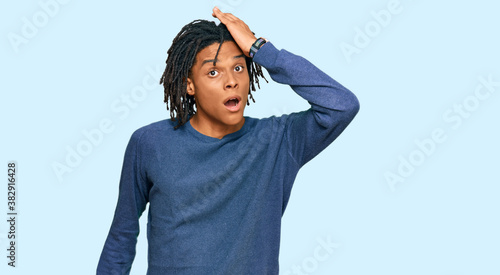 Young african american man wearing casual winter sweater surprised with hand on head for mistake, remember error. forgot, bad memory concept. © Krakenimages.com