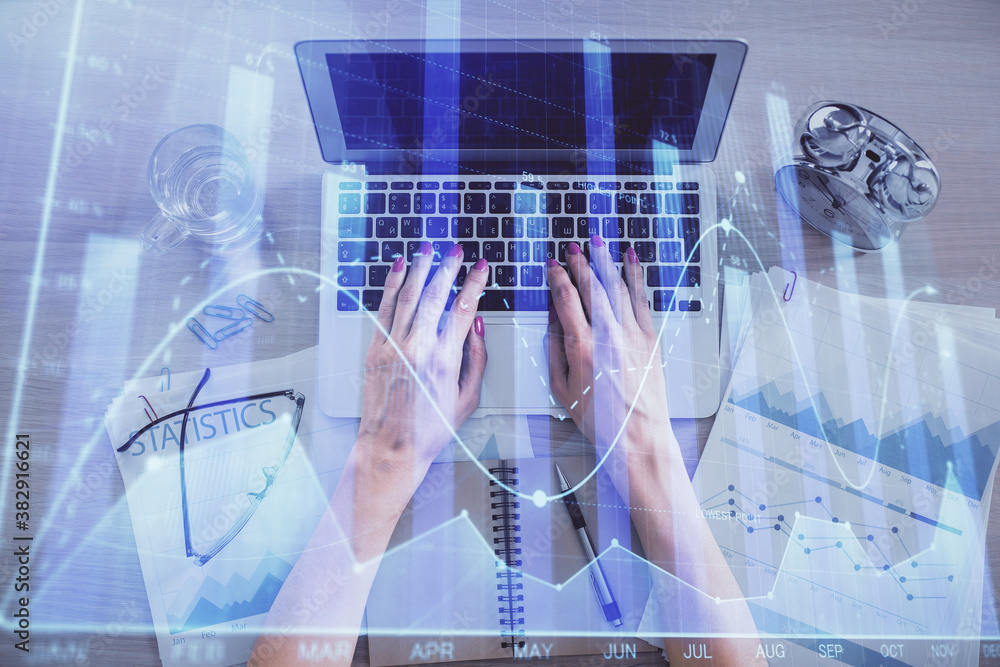 Double exposure of woman hands working on computer and forex graph hologram drawing. Top View. Financial analysis concept. Double exposure of woman hands working on computer and forex graph hologram drawing. Top View. Financial analysis concept.
