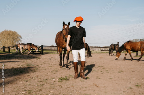 man walking carrying horse to the stable