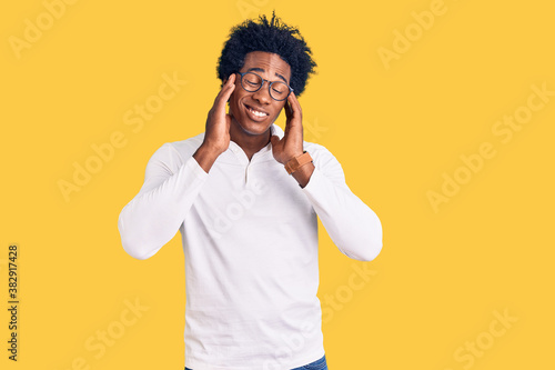 Handsome african american man with afro hair wearing casual clothes and glasses with hand on head  headache because stress. suffering migraine.