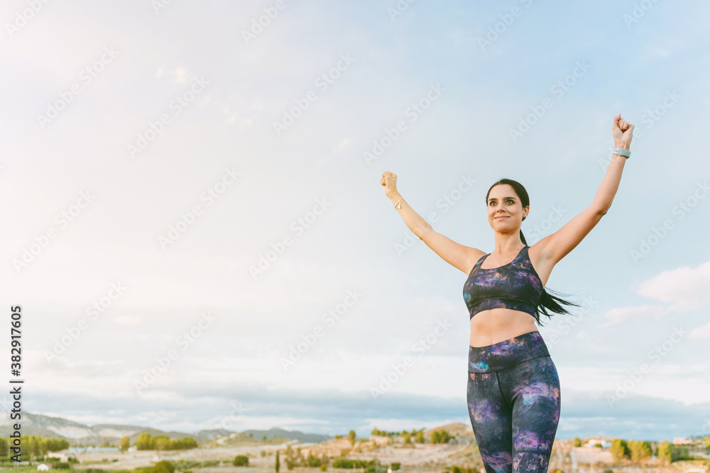Woman standing with her hands up, reaching the top. Successful female runner with open arms on top of the mountain. Magnificent summer landscape. Woman standing with her hands up, reaching the top. Successful female runner with open arms on top of the mountain. Magnificent summer landscape.