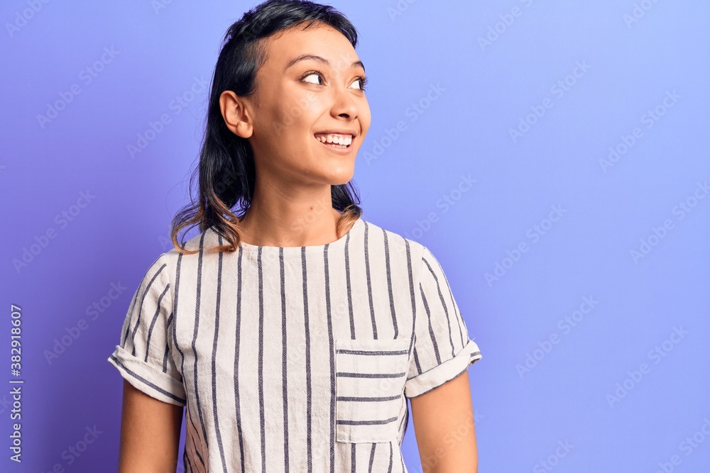 Young woman wearing casual clothes looking away to side with smile on face, natural expression. laughing confident. Young woman wearing casual clothes looking away to side with smile on face, natural expression. laughing confident.