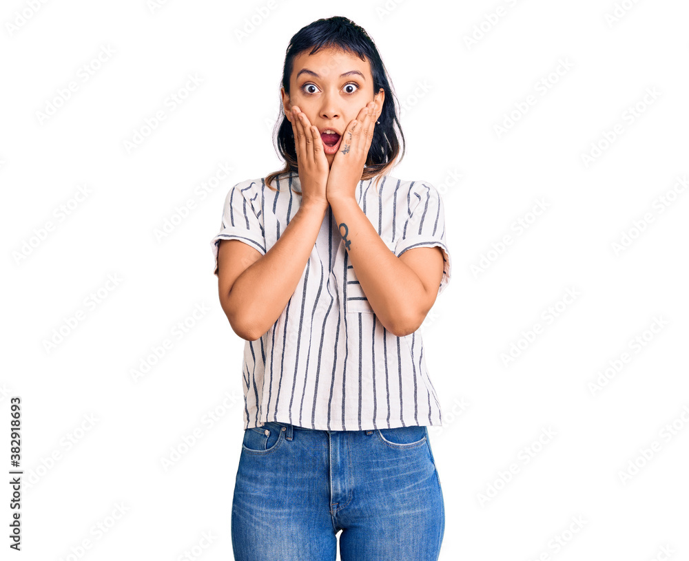 Young woman wearing casual clothes afraid and shocked, surprise and amazed expression with hands on face Young woman wearing casual clothes afraid and shocked, surprise and amazed expression with hands on face