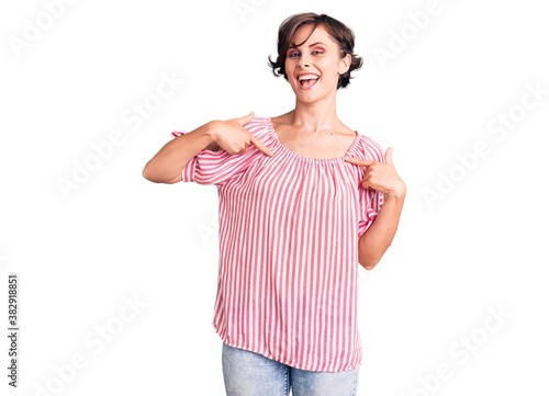 Beautiful young woman with short hair wearing casual summer clothes looking confident with smile on face, pointing oneself with fingers proud and happy.