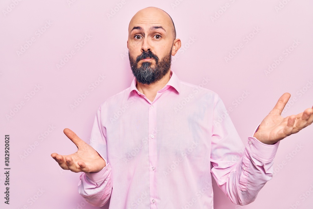 Young handsome man wearing business clothes clueless and confused expression with arms and hands raised. doubt concept. Young handsome man wearing business clothes clueless and confused expression with arms and hands raised. doubt concept.