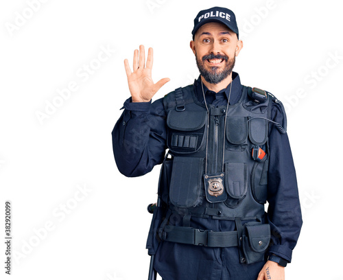 Young handsome man wearing police uniform showing and pointing up with fingers number five while smiling confident and happy.