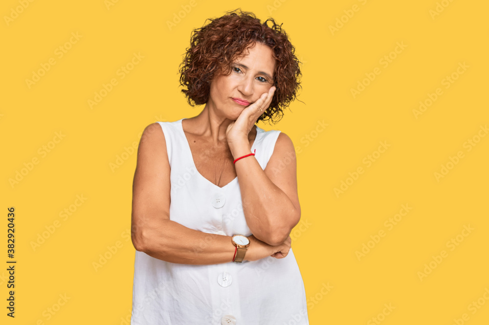 Beautiful middle age mature woman wearing casual white shirt thinking looking tired and bored with depression problems with crossed arms. Beautiful middle age mature woman wearing casual white shirt thinking looking tired and bored with depression problems with crossed arms.
