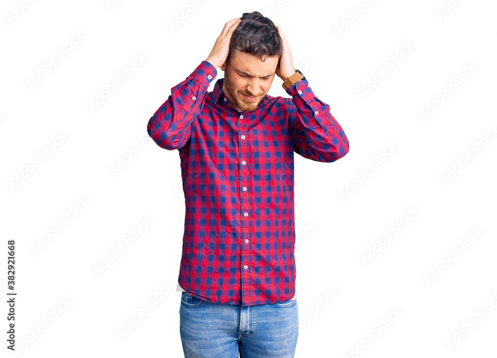 Handsome young man with bear wearing casual shirt suffering from headache desperate and stressed because pain and migraine. hands on head. Handsome young man with bear wearing casual shirt suffering from headache desperate and stressed because pain and migraine. hands on head.
