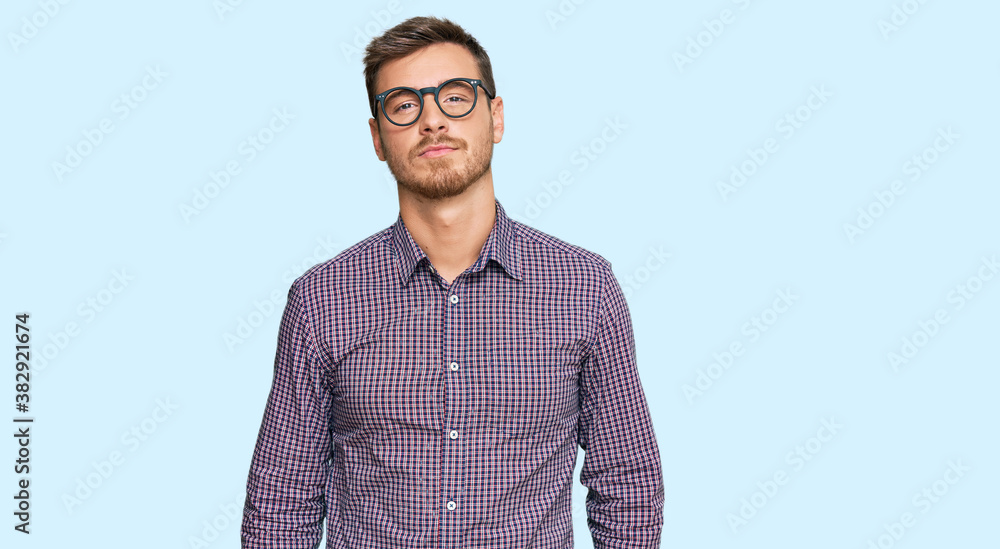 Handsome caucasian man wearing casual clothes and glasses relaxed with serious expression on face. simple and natural looking at the camera. Handsome caucasian man wearing casual clothes and glasses relaxed with serious expression on face. simple and natural looking at the camera.