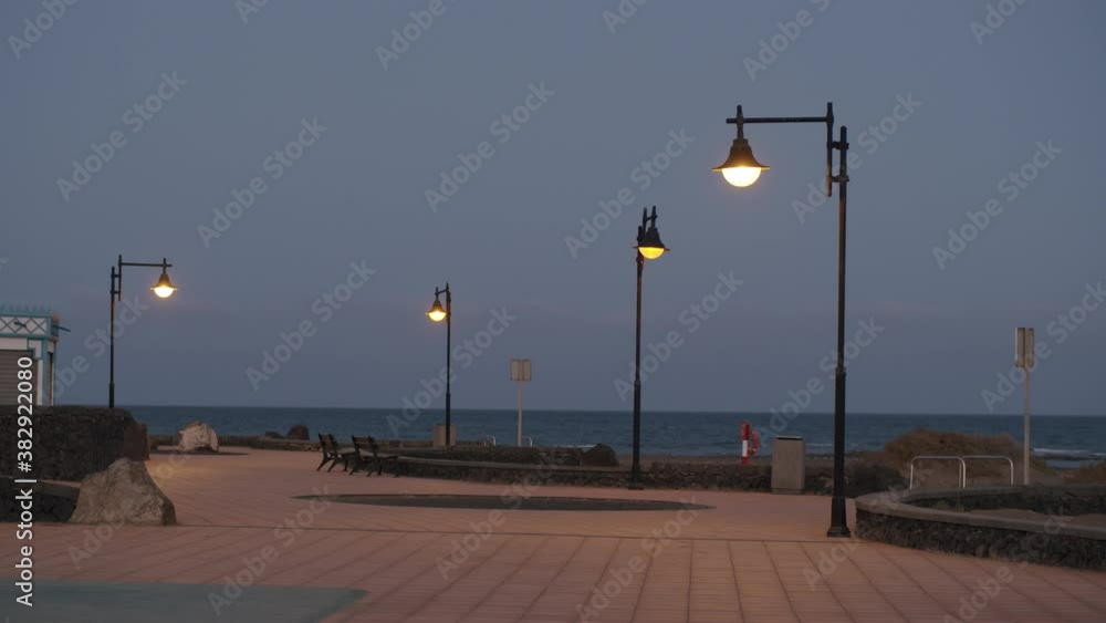 Empty seaside promenade with streetlights on for nobody Empty seaside promenade with streetlights on for nobody