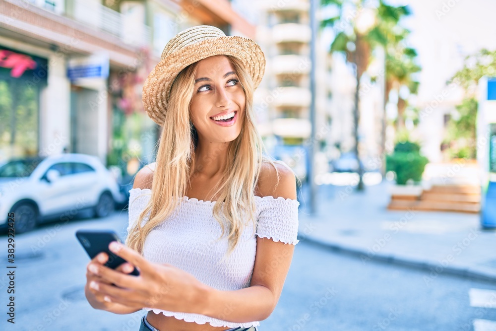 Young blonde tourist girl smiling happy using smartphone at the city.