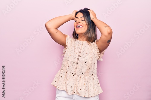 Young beautiful brunette woman wearing casual clothes smiling happy and confident. Standing with smile on face over isolated pink background