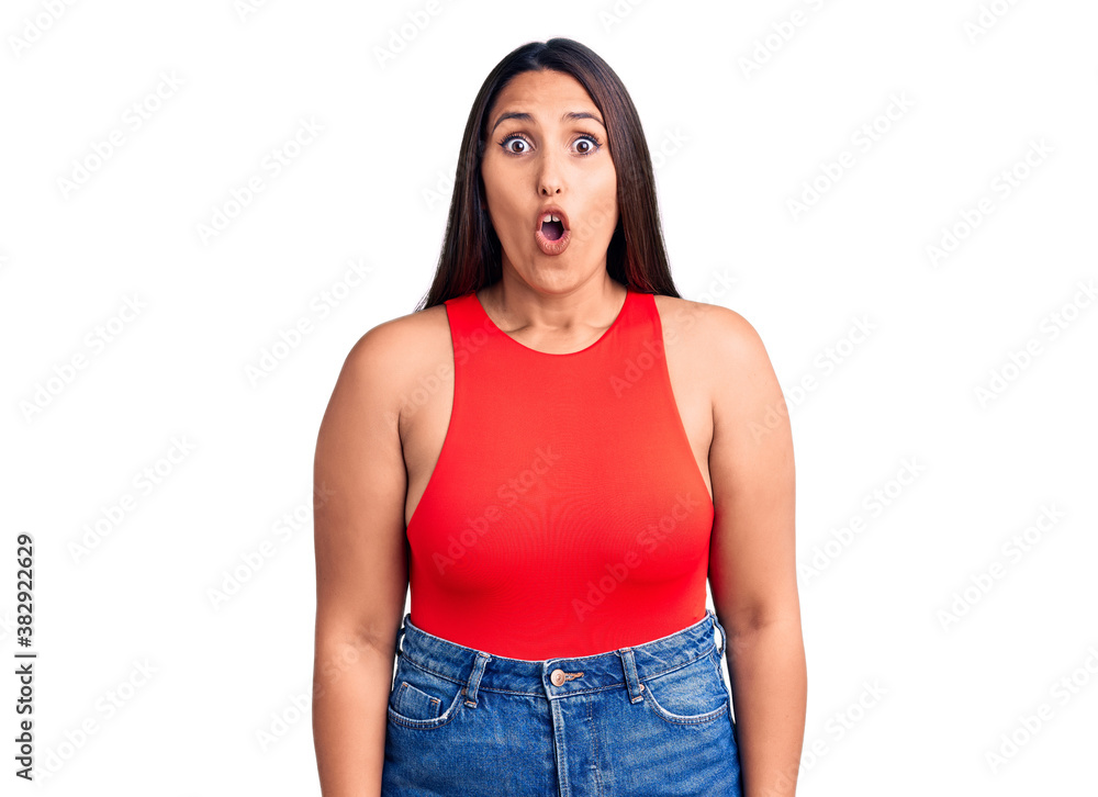 Obraz premium Young beautiful brunette woman wearing casual sleevelss t-shirt scared and amazed with open mouth for surprise, disbelief face