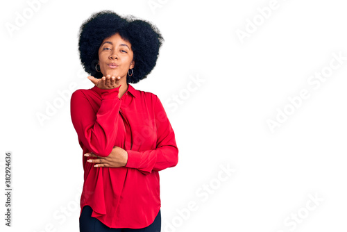 Young african american girl wearing casual clothes looking at the camera blowing a kiss with hand on air being lovely and sexy. love expression.