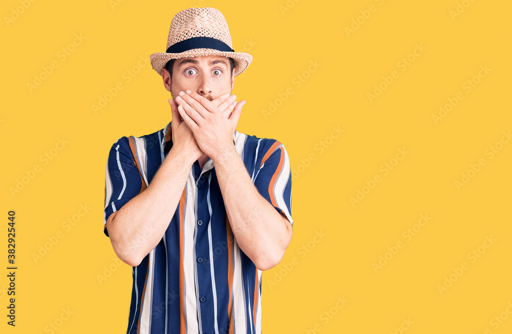 Young handsome caucasian man wearing summer hat shocked covering mouth with hands for mistake. secret concept. Young handsome caucasian man wearing summer hat shocked covering mouth with hands for mistake. secret concept.