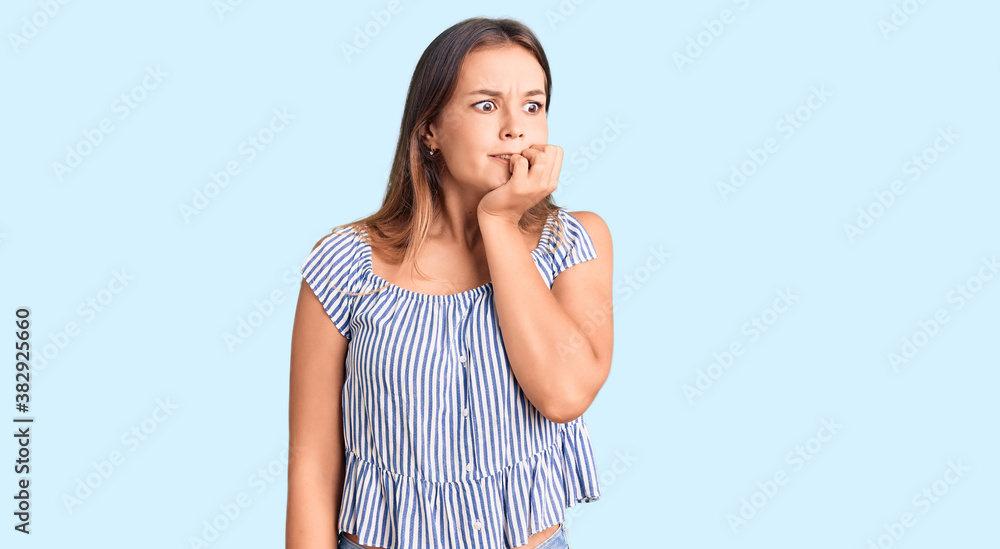 Beautiful caucasian woman wearing casual clothes looking stressed and nervous with hands on mouth biting nails. anxiety problem.