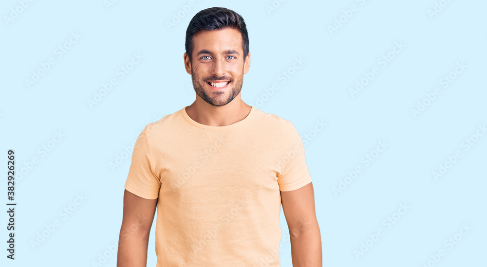 Fototapeta premium Young hispanic man wearing casual clothes with a happy and cool smile on face. lucky person.