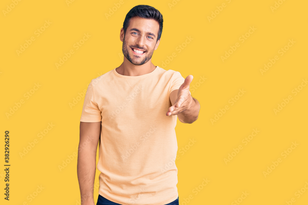 Young hispanic man wearing casual clothes smiling friendly offering handshake as greeting and welcoming. successful business. Young hispanic man wearing casual clothes smiling friendly offering handshake as greeting and welcoming. successful business.