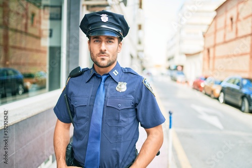 Bilde på lerret young handsome hispanic policeman wearing police uniform