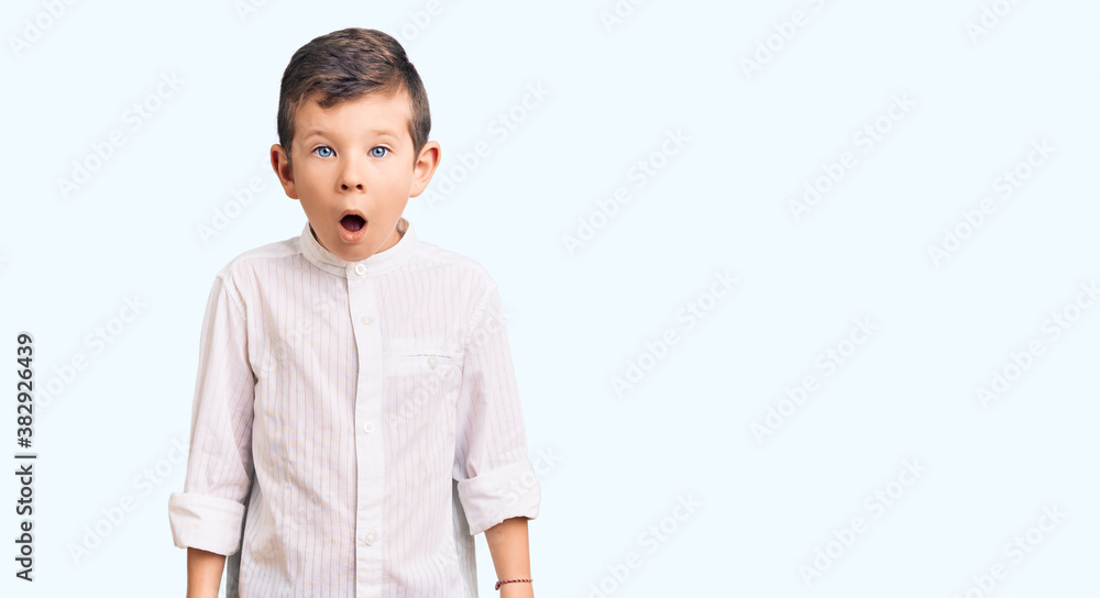 Cute blond kid wearing elegant shirt afraid and shocked with surprise and amazed expression, fear and excited face. Cute blond kid wearing elegant shirt afraid and shocked with surprise and amazed expression, fear and excited face.