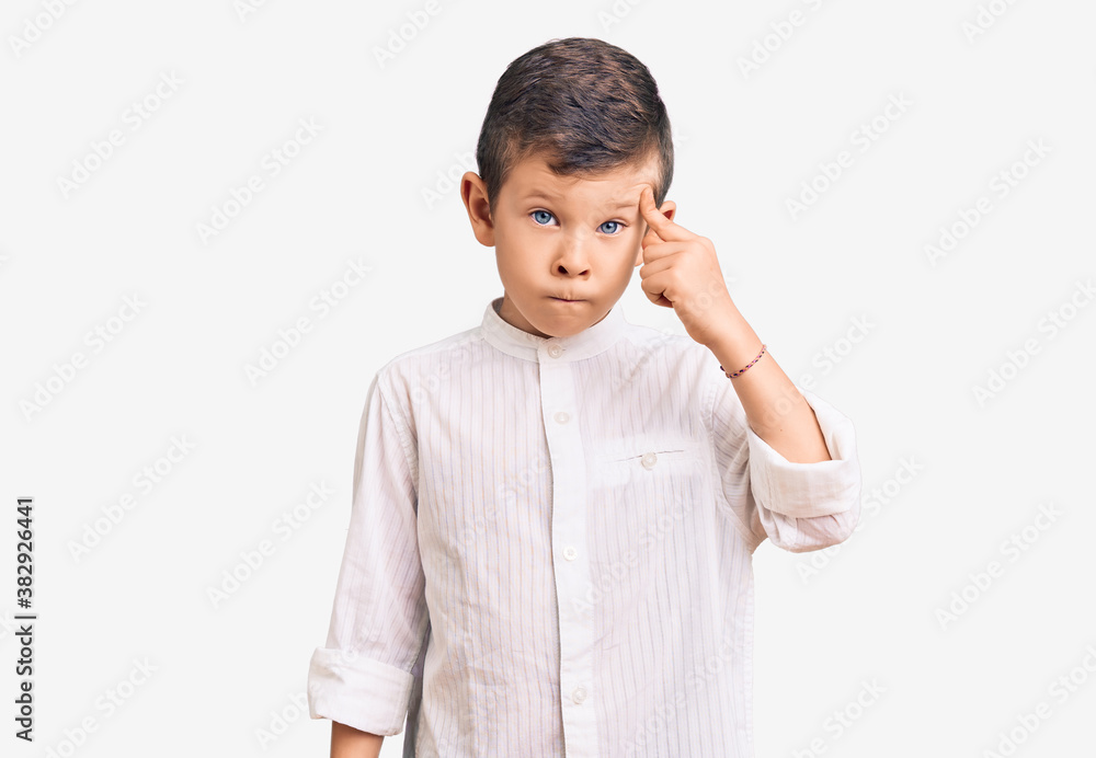 Cute blond kid wearing elegant shirt pointing unhappy to pimple on forehead, ugly infection of blackhead. acne and skin problem